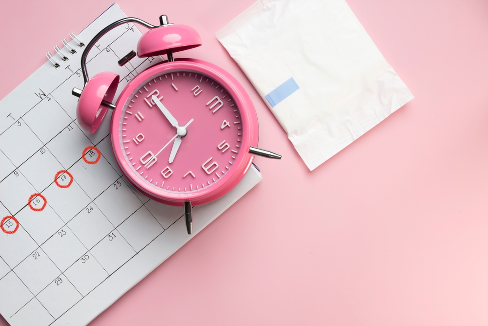 clock and pad with calendar marked with period dates